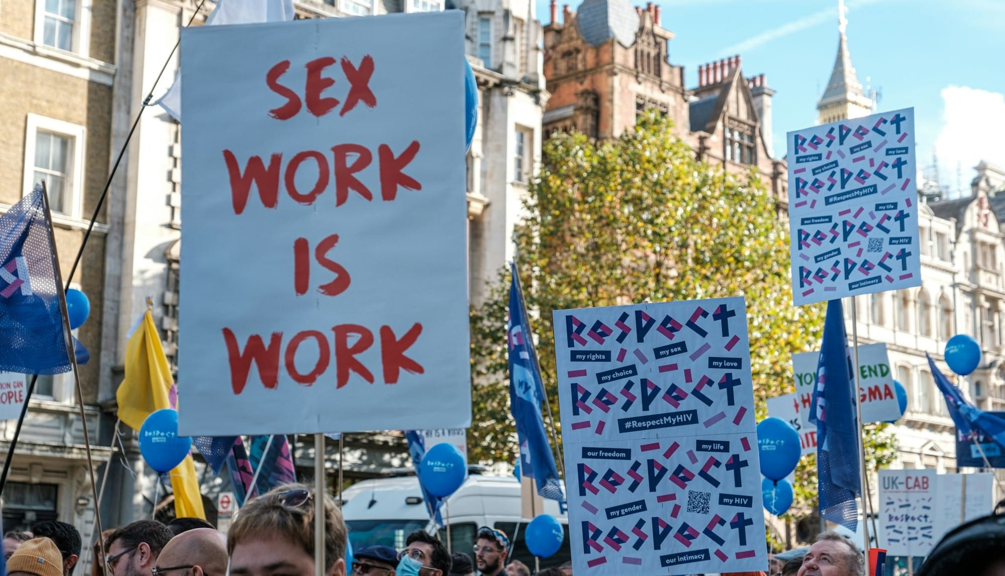 a group of people holding signs and balloons