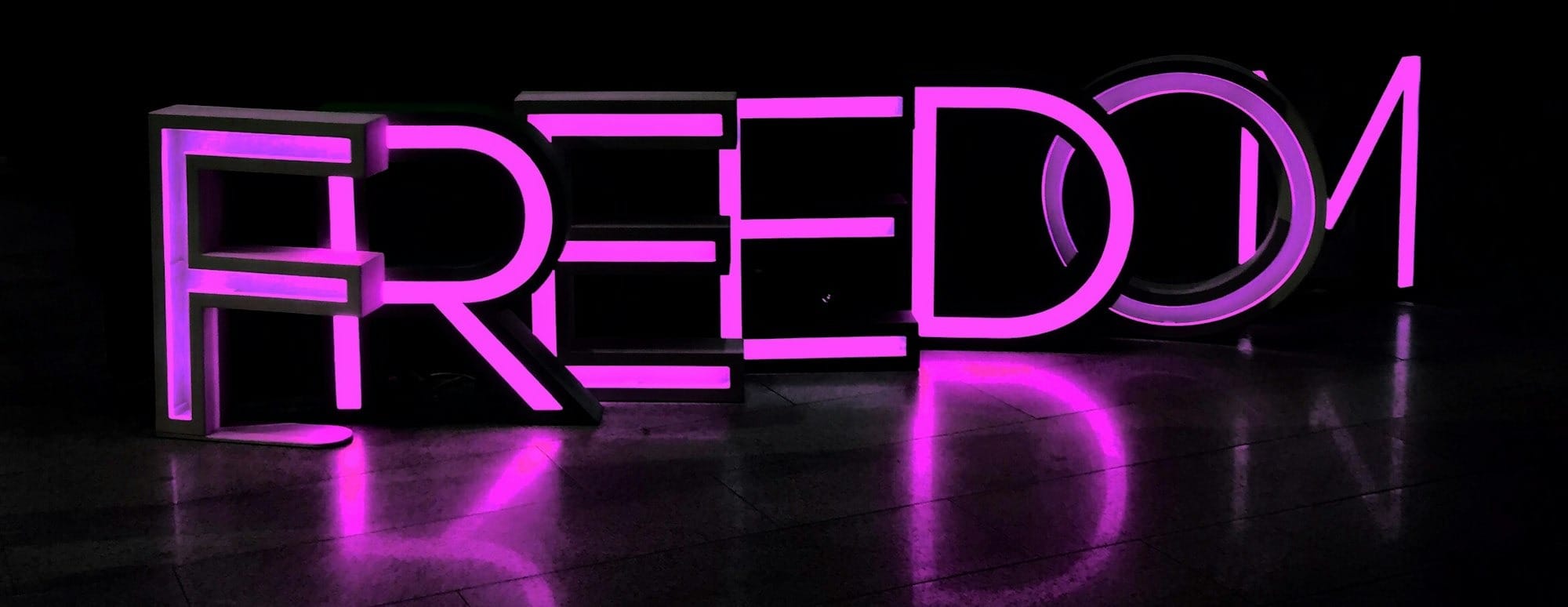 purple Freedom lighted freestanding letters on brown surface