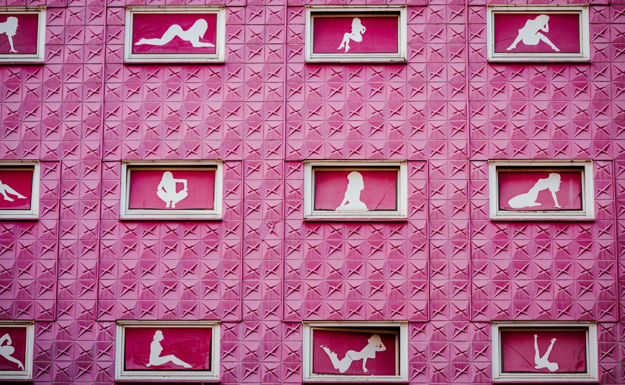 A pink building adorns silhouettes in windows.