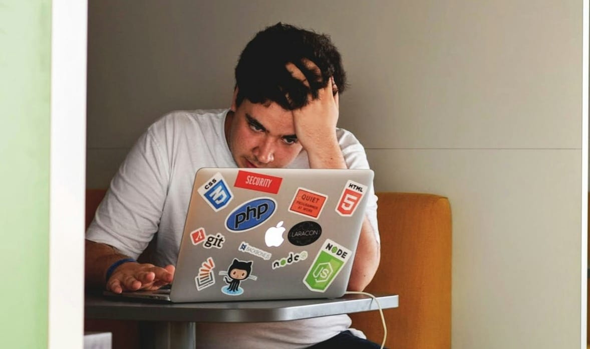 man wearing white top using MacBook